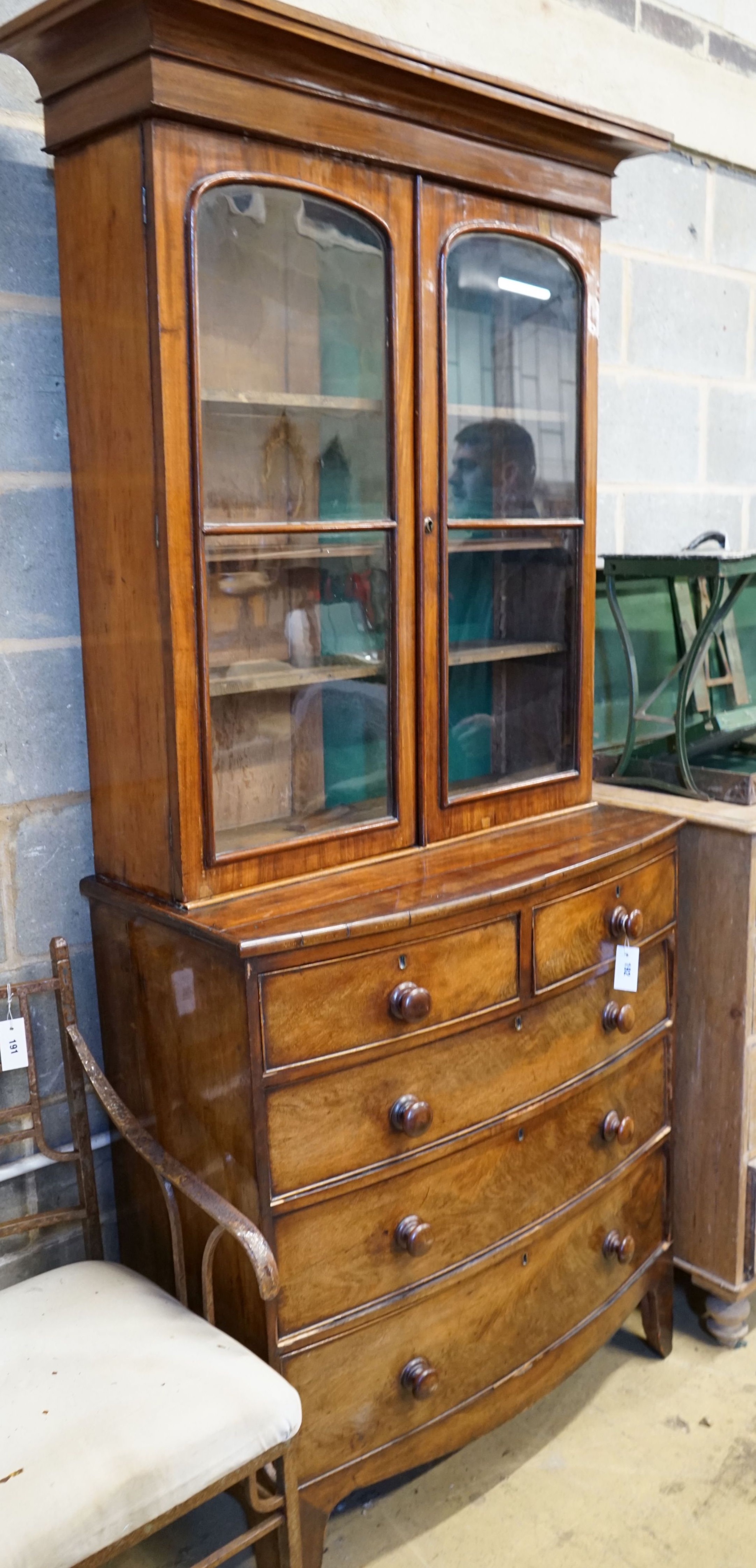 A Victorian and later mahogany bookcase on bowfront chest, width 93cm depth 46cm height 216cm